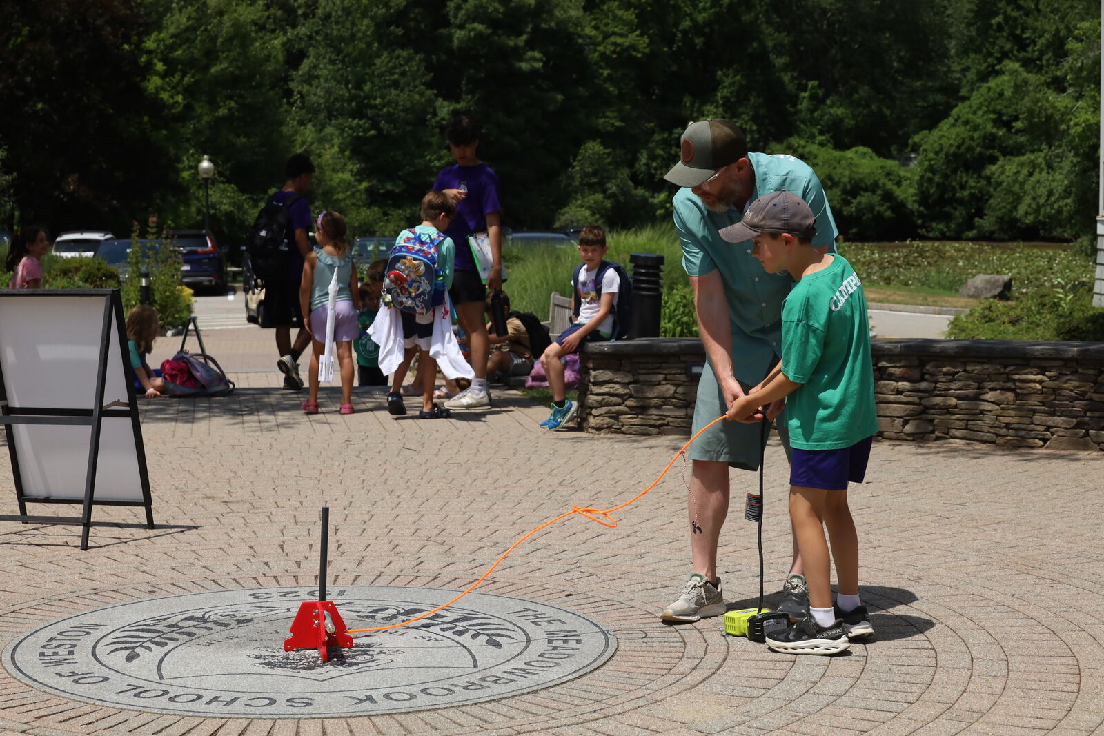 An Explorer launching a model rocket with an instructor